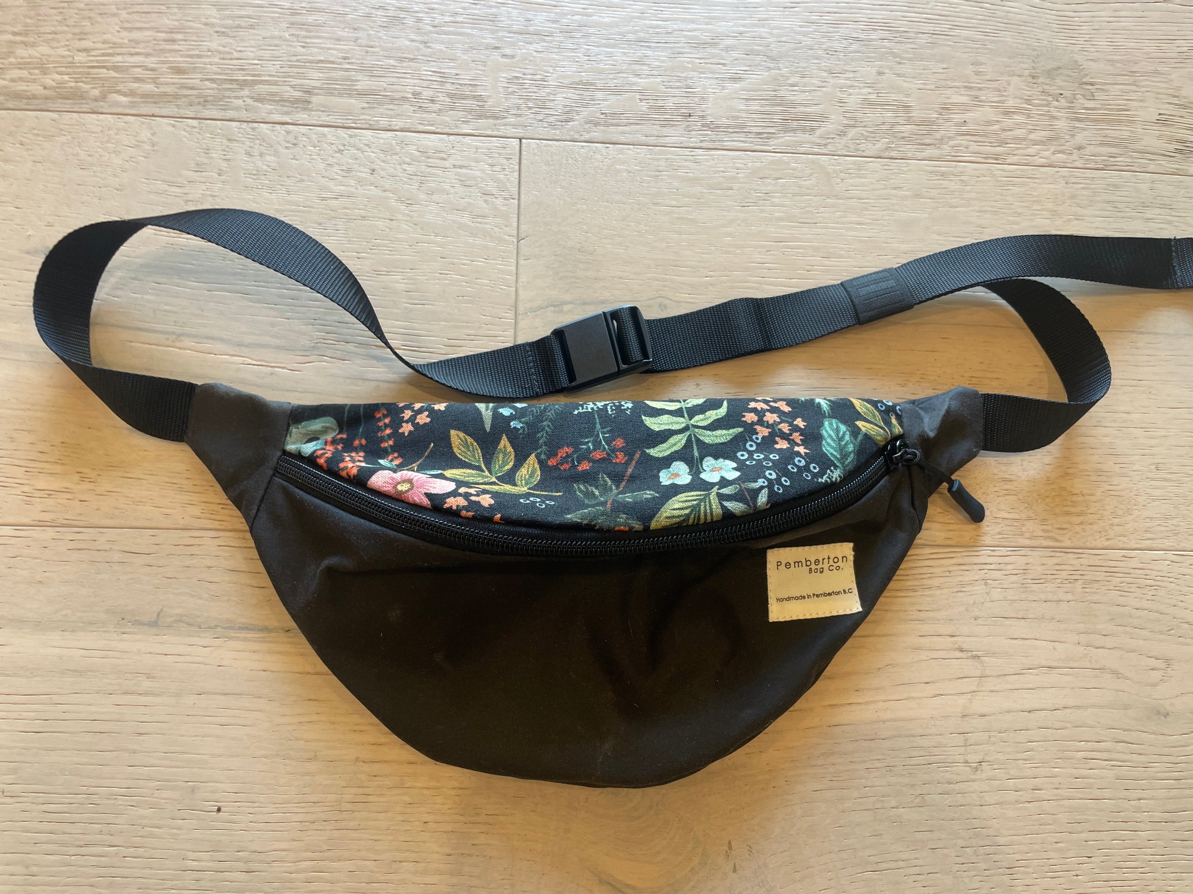 Black oilskin fanny pack with floral top.