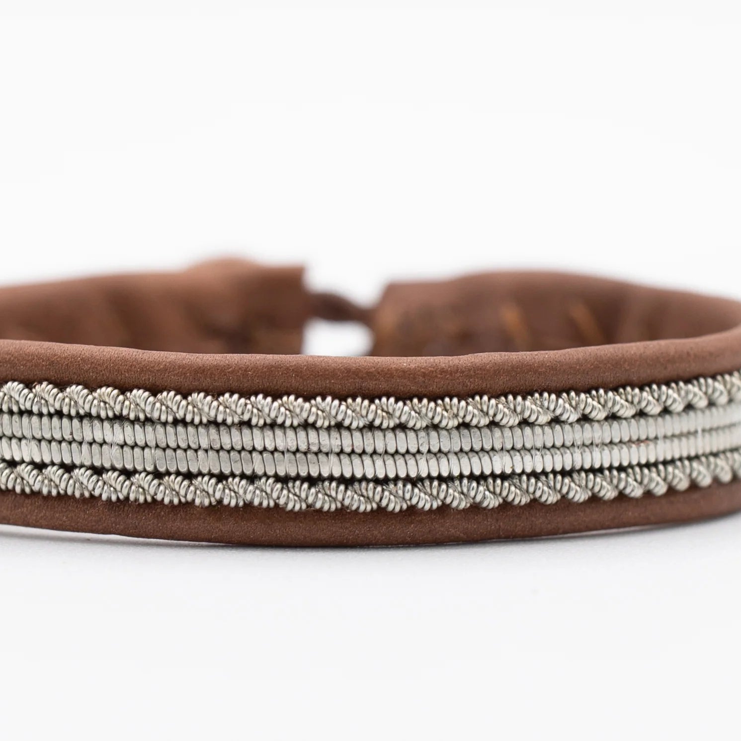 A dark brown bracelet with a silver-thread pattern.